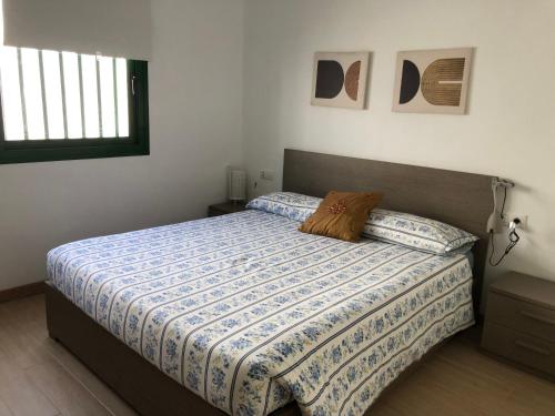 a bedroom with a bed with a blue and white comforter at Casa BAU in Los Pocillos
