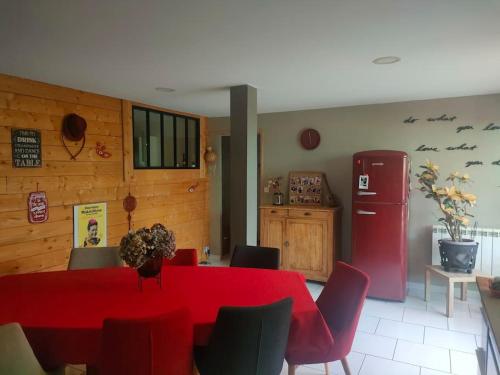 une salle à manger avec une table rouge et un réfrigérateur rouge dans l'établissement Beau loft lumineux et spacieux à 2 pas de Rouen, à Le Houlme