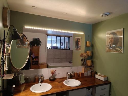 une salle de bain avec deux lavabos et un grand miroir dans l'établissement Beau loft lumineux et spacieux à 2 pas de Rouen, à Le Houlme