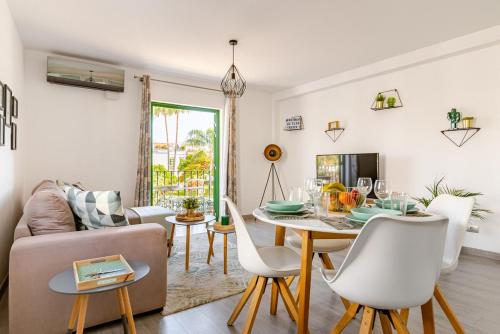 una sala de estar con una mesa y un sofá en La Flor Beach, en Puerto de Mogán