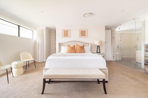 a white bedroom with a large bed with orange pillows at Luxury Spacious 5 Bedroom Family Modern Villa Sleeps 10 in Waterford
