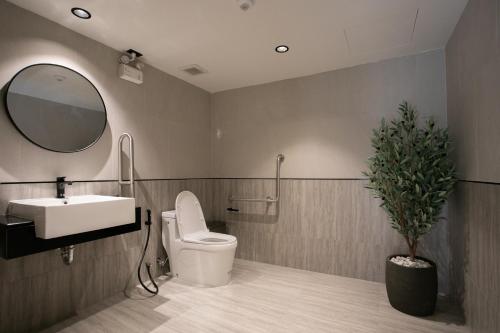 a bathroom with a sink and a toilet and a mirror at Pillow B Hotel in Ban Zong Katiam