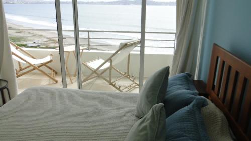 um quarto com uma cama e vista para o oceano em La Serena Departamento vista al mar em La Serena