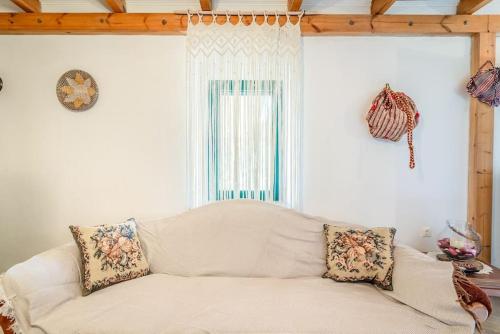 a white couch in a living room with a window at Traditional Stonehouse in the Village in Megáli Vrísi