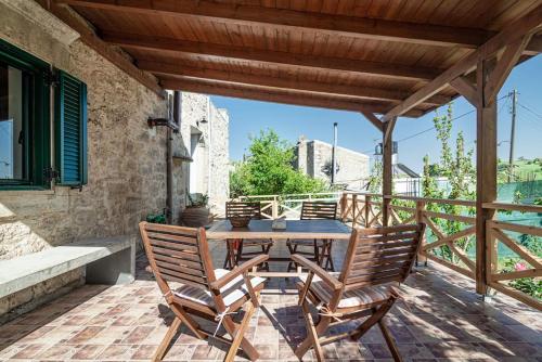 a wooden table and chairs on a patio at Traditional Stonehouse in the Village in Megáli Vrísi