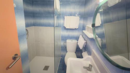 Un baño con inodoro y ducha de cristal. en BLUESEA Continental, en Tossa de Mar