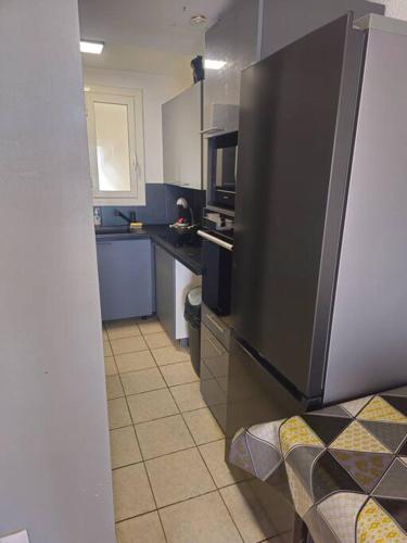 Il comprend une cuisine équipée d'un réfrigérateur et d'une cuisinière. four supérieur dans l'établissement Appartement sur la plage, à Fos-sur-Mer