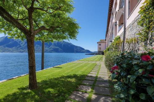 a sidewalk next to a building with a tree and water at Yachting Residence in Ghiffa