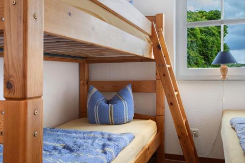 a bunk bed with a blue pillow in a bunk room at Haus Seeadler Wohnung 13 in Ostseebad Koserow