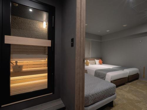a hotel room with two beds and a balcony at Villa Fontaine Tokyo Shinjuku in Tokyo