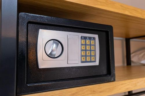 a microwave oven on a wooden shelf with a control panel at Franklin Rooms in Sarandë