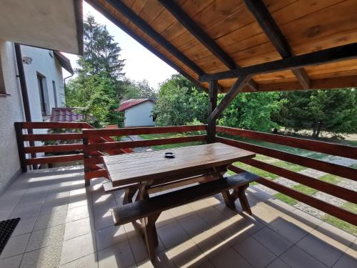 a wooden table on a porch with a bench at Ośrodek Wypoczynkowy "U Kulasa" in Warchały