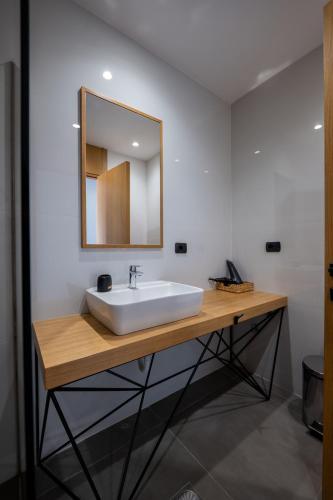 a bathroom with a white sink and a mirror at Franklin Rooms in Sarandë