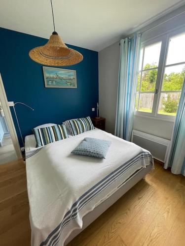 une chambre avec un lit avec un mur bleu dans l'établissement La Maison d'Été, à Noirmoutier-en-l'lle