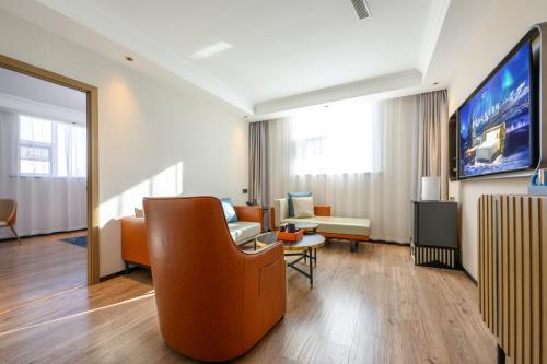 a living room with a couch and a tv at 宜尚酒店太原长风街店 in Taiyuan