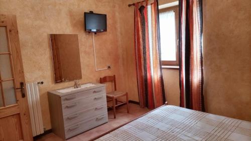 a bedroom with a bed and a dresser and a mirror at La casa di Eleonora in Campodolcino