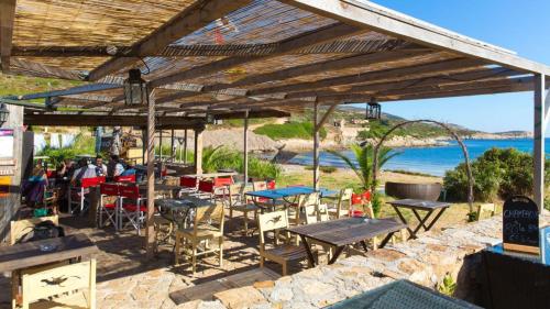 un groupe de tables et de chaises sous une pergola en bois dans l'établissement chambre et salle de bain indépendantes à 200m de la plage de Fabrégas, à La Seyne-sur-Mer