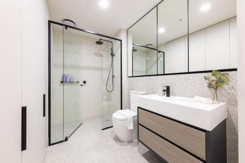 a bathroom with a toilet and a sink and a shower at Richmond Apartments with Urban Rest in Melbourne