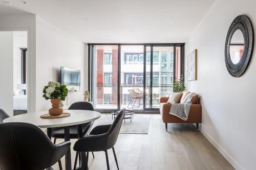 a living room with a table and chairs at Richmond Apartments with Urban Rest in Melbourne