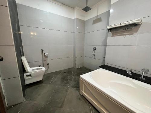a bathroom with a toilet and a sink at Rudraksh Resort and Hotel in Rewāri
