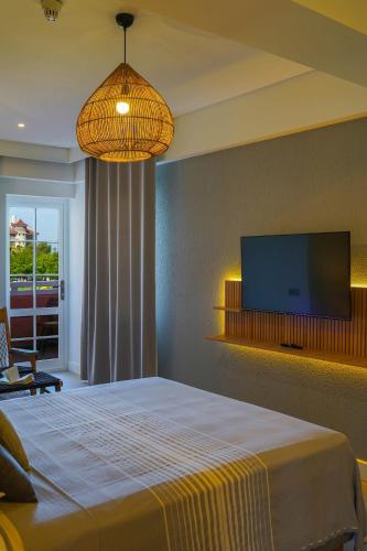 a bedroom with a bed and a flat screen tv at Hotel Club-E in Fethiye