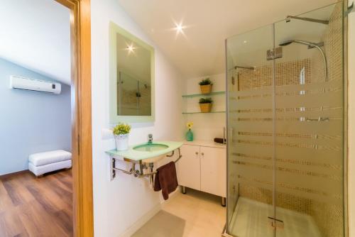 een badkamer met een wastafel en een glazen douche bij Ideal Property Mallorca - Xiscama in Alcudia