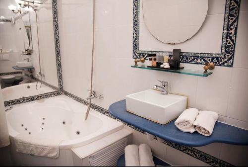 a bathroom with a sink and a tub and a mirror at וילה תהילה המחודש - The new Villa Tehila in Rosh Pinna
