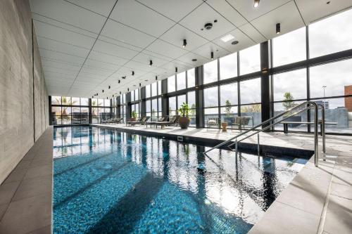 a swimming pool in a building with windows at Richmond Apartments with Urban Rest in Melbourne