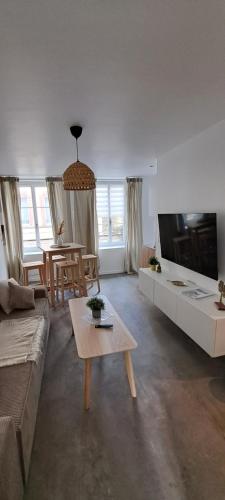 un salon avec un canapé et une table dans l'établissement Le balinais , en hyper centre rue au calme avec parking, à Cherbourg en Cotentin