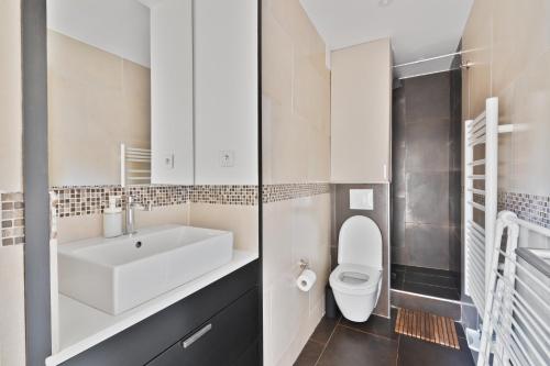 une salle de bain avec un lavabo blanc et des toilettes dans l'établissement Appartement Quartier Opéra 2 Free Netflix, à Paris