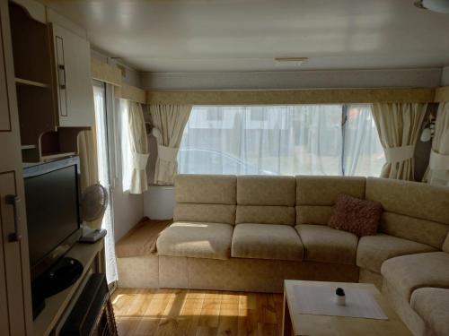 a living room with a couch and a large window at Przyczepa holenderska in Ińsko