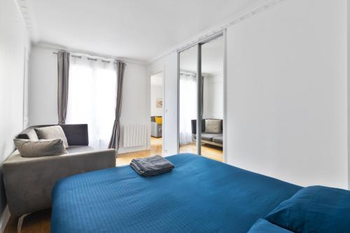 - une chambre avec un lit bleu et une chaise dans l'établissement Appartement Quartier Opéra 2 Free Netflix, à Paris