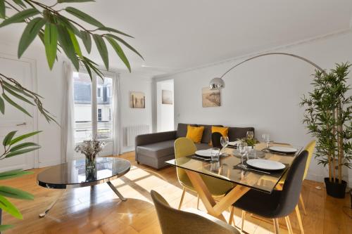 un salon avec une table et un canapé dans l'établissement Appartement Quartier Opéra 2 Free Netflix, à Paris