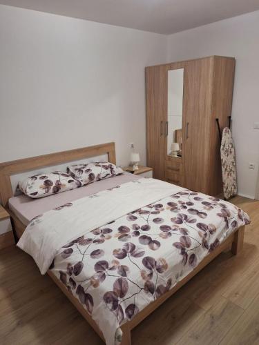 ein Schlafzimmer mit einem Bett mit geblümter Tagesdecke in der Unterkunft Apartman Porto in Tivat