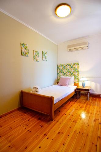 a bedroom with a bed and a wooden floor at Kefalonian Luxury Villas in Kástron