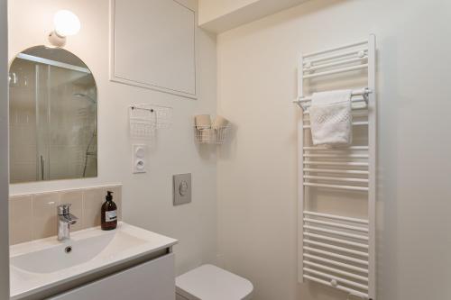une salle de bain blanche avec un lavabo et des toilettes dans l'établissement Le Perchoir - Appt Rennes parking privé, à Rennes