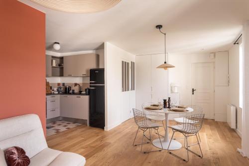 une cuisine et un salon avec une table et des chaises dans l'établissement Le Perchoir - Appt Rennes parking privé, à Rennes