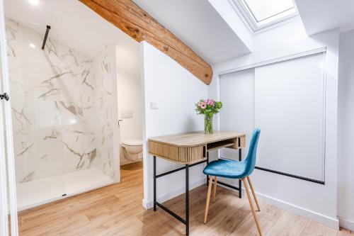 a desk and chair in a room with a marble wall at Gîte Le Figuier des Alpilles- 6p in Eygalières