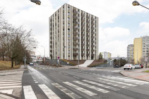 an empty city street with a tall building at Stay2gether Japandi Homestay for 4 - Metro B Luka in Prague