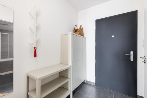a white refrigerator with a cat sitting on top of it at Stay2gether Japandi Homestay for 4 - Metro B Luka in Prague