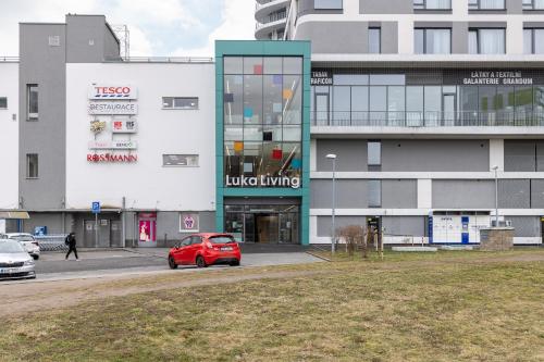a red car parked in front of a building at Stay2gether Japandi Homestay for 4 - Metro B Luka in Prague