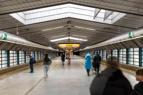a group of people walking in a subway station at Stay2gether Japandi Homestay for 4 - Metro B Luka in Prague