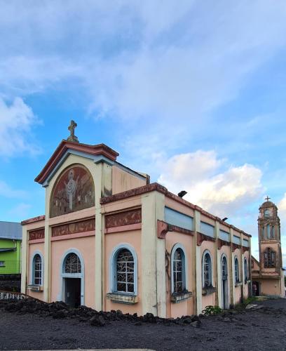 an old building with a cross on top of it at Ti Kaz citron in Sainte-Rose
