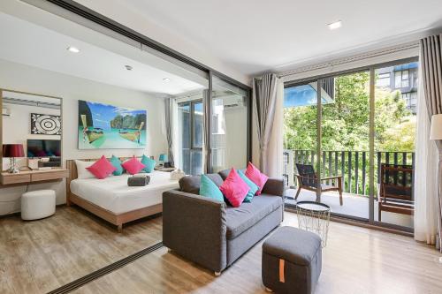a living room with a bed and a couch at The Deck Condominium Patong Beach in Patong Beach
