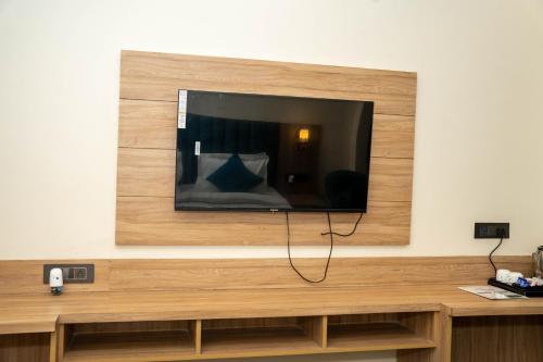 a flat screen tv hanging on a wall at Hotel W Grand - A Boutique Hotel in Haridwār