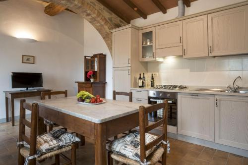 a kitchen with a large wooden table and chairs at Agriturismo Il Ferralino in SantʼAngelo in Colle