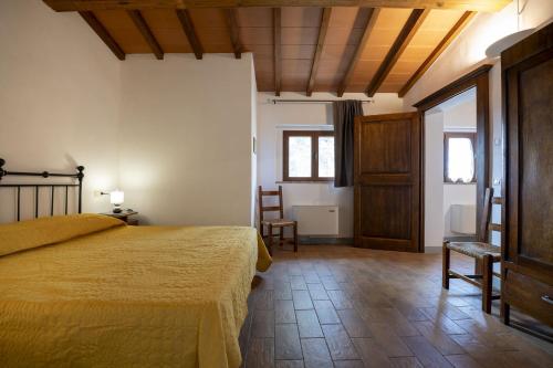 a bedroom with a bed and a table and chairs at Agriturismo Il Ferralino in SantʼAngelo in Colle