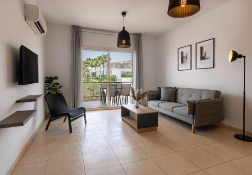 a living room with a couch and a tv at Phaedrus Living Limassol Pyrgos Seaside Flat in Limassol