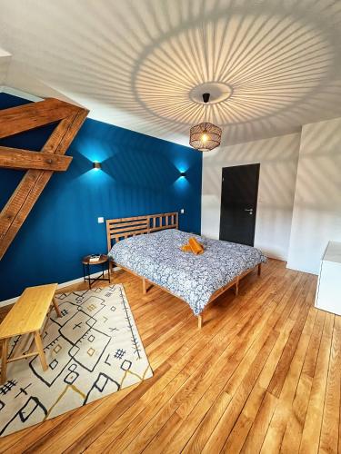 une chambre avec un lit et un mur bleu dans l'établissement Appartement hyper centre lit King Seize, à Épinal