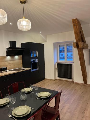 une cuisine et une salle à manger avec une table et des chaises dans l'établissement Appartement hyper centre lit King Seize, à Épinal